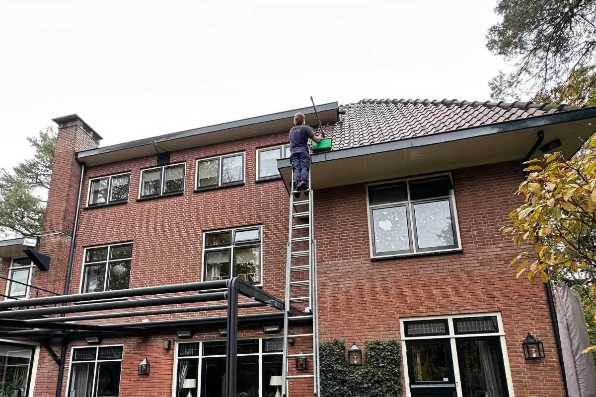 Dakgootonderhoud aan een woning in uitvoering