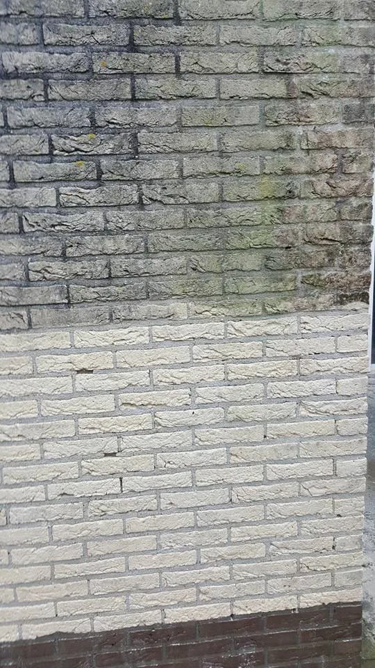 Gereinigd en vervuild deel van een gemetselde gevel
